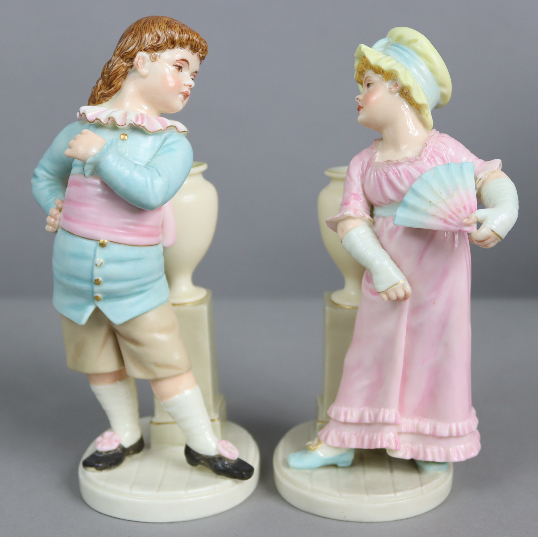 A pair of Royal Worcester porcelain ‘Kate Greenaway’ type figures of a boy & girl, each standing