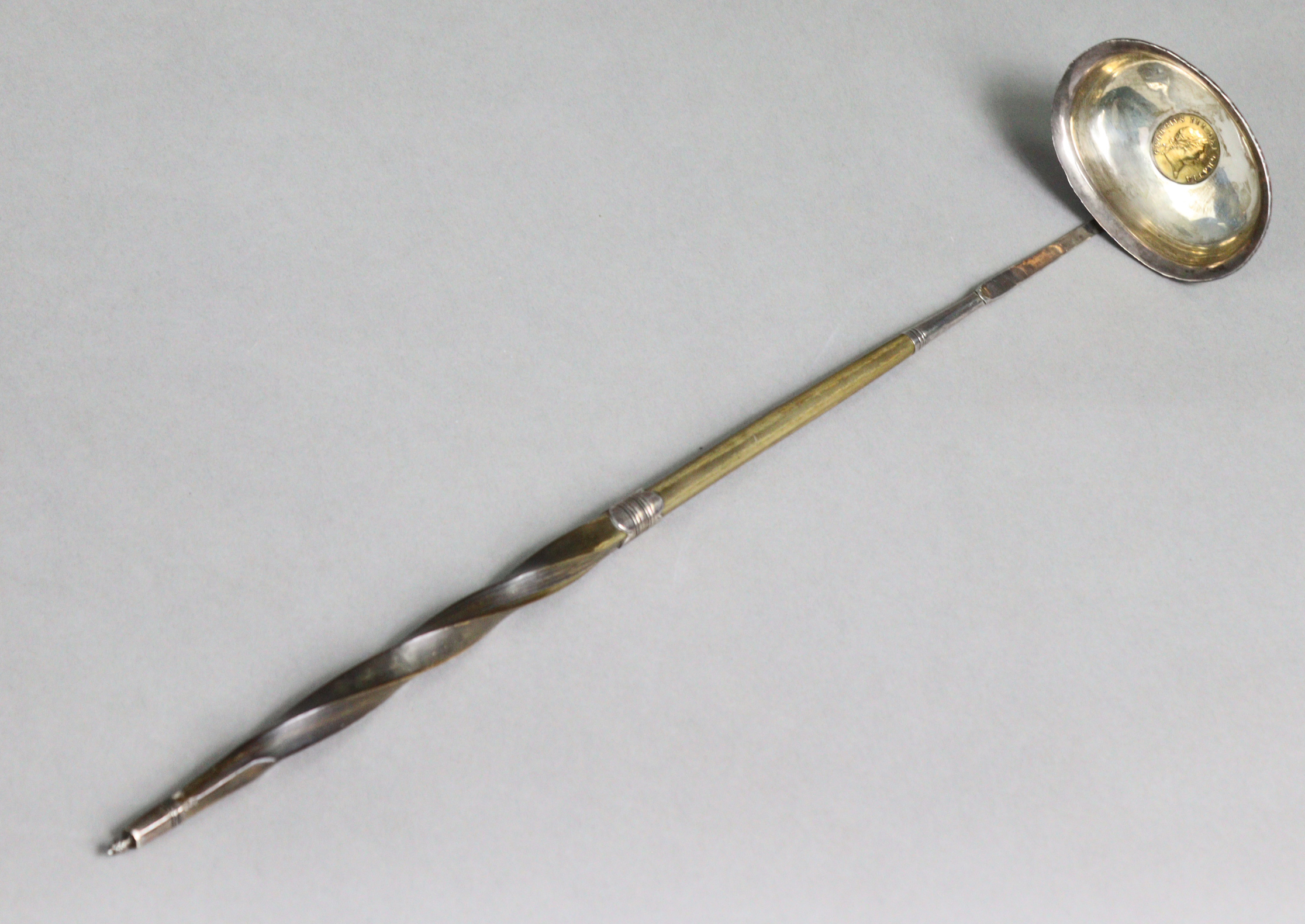 A silver toddy 'coin' ladle with spiral-twist whalebone handle, inset George III half guinea to the