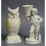 A Belleek porcelain candle holder in the form of a standing boy holding a basket on his shoulder, 8