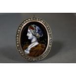 A 19th century Limoges enamel oval pendant painted with the bust of a noblewoman in the