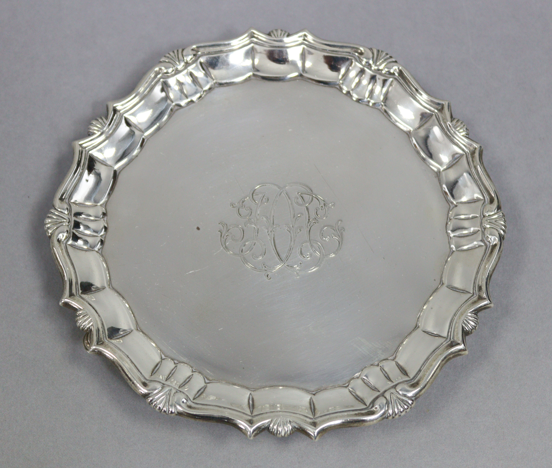 A George II silver waiter with “pie-crust” edge, engraved monogram, & on three pad feet, 6½”