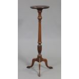 A reproduction mahogany torchere, with moulded edge to the circular top, on vase-turned & fluted