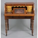 An early Victorian walnut roll-top desk with tambour shutter, enclosing a fitted interior with