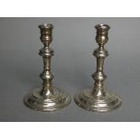 A pair of silver candlesticks in the early 18th century style, with round slender baluster columns &