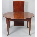 An Edwardian inlaid mahogany circular extending dining table with one addition leaf, on square
