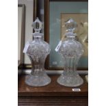 A pair of heavy cut-glass decanters, each of ovoid form & with finial stopper, 11” high; together