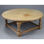 A large pine coffee table with moulded edge to the circular top, & on turned legs with plain