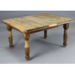 A late 19th/early 20th century pine extending dining table, with canted corners & moulded edge to