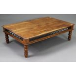 A large teak coffee table with rectangular top, having wrought-iron frieze & on turned legs, 53”