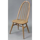 An Ercol light elm spindle-back dining chair with hard seat, & on round tapered legs with spindle