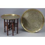 An eastern brass engraved tray-top occasional table on hardwood folding stand, 23” diam. x 20½”