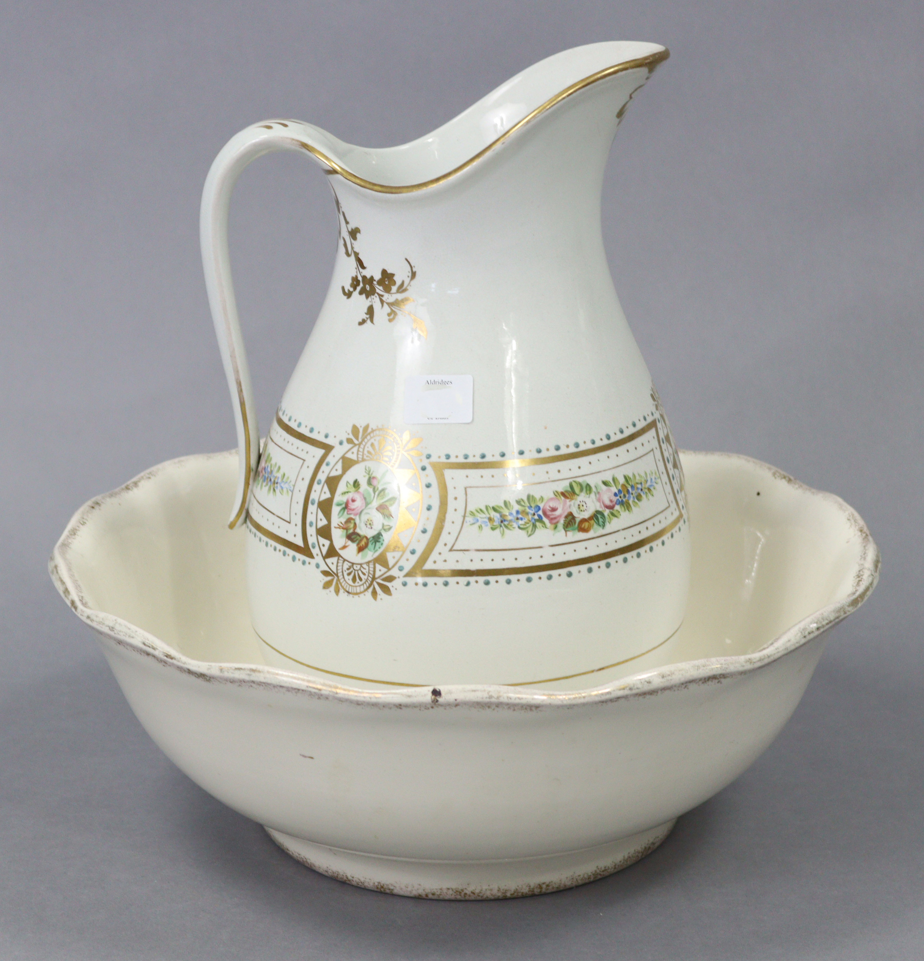 A late Victorian toilet jug & basin of white ground & with multicoloured floral banded decoration.