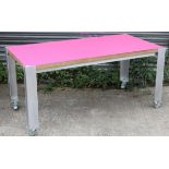 A Stenco office table with pink laminate top, 63” long x 29” high x 31½” deep.
