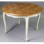 A continental-style oak circular extending dining table with centre leaf, the cream painted