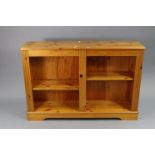 A pine dwarf standing open bookcase with two adjustable shelves, & on a plinth base, 47” wide x 31½”