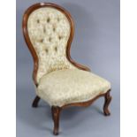A Victorian beech-frame nursing chair with buttoned back & padded seat, & on short cabriole legs.