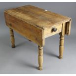 A pine drop-leaf kitchen table (reduced in height), fitted end drawer & on turned legs, 32¼” wide