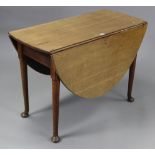 A late 19th/early 20th century oak oval drop-leaf dining table, on four round tapered legs with