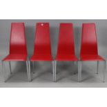 A set of four modern dining chairs with red vinyl seats & backs, & on chrome legs.
