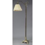 An Edwardian-style brass standard lamp, with scroll-arm & on triform base, with shade.