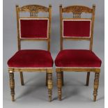 A pair of late Victorian beech rail-back dining chairs with padded seats, & on ring-turned tapered