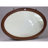 An Edwardian mahogany frame oval wall mirror with beaded edge & inset bevelled plate, 26½” x 38”.