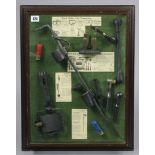 A display of various gamekeeper’s accessories, in a glazed case, 22½” x 17½”.