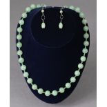 A jade necklace with gilt-metal clasp, 22” long; & a pair of jade earrings.