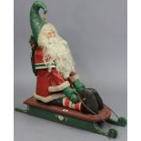 A vintage-style painted wooden & fabric Santa-on-a-sleigh Christmas ornament, 31” wide x 31½” high.