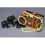 Various items of costume jewellery; two carved ebony elephant models; & a rosewood trinket box,