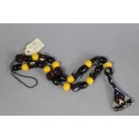 A bead necklace strung with alternating yellow & black coloured beads, having triangular beadwork