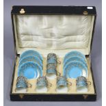A set of six Coalport china coffee cans & saucers of pale blue ground & with gold scroll decoration,