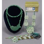 Three jade pendant necklaces; a jade bracelet; & a pair of jade earrings.
