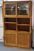 A LAURA ASHLEY LIGHT OAK TALL CABINET (in three sections), the upper part with two adjustable