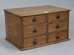 An oak table-top collector’s chest, fitted two ranks of three long drawers with turned knob handles,