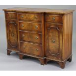 A reproduction mahogany small break-front side cabinet, fitted four long graduated drawers to centre