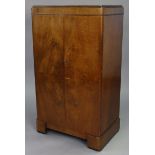 A 1930’s walnut dwarf cabinet, fitted seven sliding trays enclosed by a pair of panel doors, & on