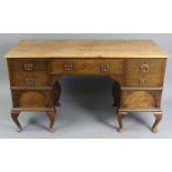 An 18th century-style oak knee-hole desk, fitted with an arrangement of five drawers & a pair of