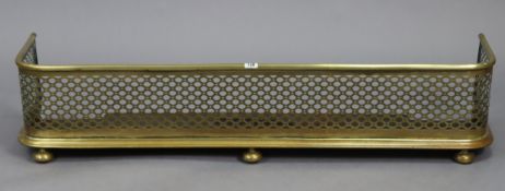 An early 20th century brass fender with pierced frieze, 47” long.