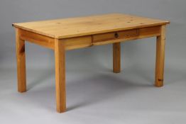 A pine kitchen table with rectangular top, fitted frieze drawer to one side, & on four square