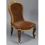 A Victorian mahogany spoon back nursing chair upholstered brown velour, & on short cabriole legs