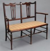 An Edwardian show-wood frame two-seater settee with pierced & shaped splats to the open back, with