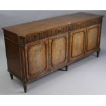 A regency-style mahogany side cabinet fitted two frieze drawers above cupboards enclosed by two