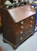 A late 18th/early 19th century mahogany bureau, the fall-front enclosing a fitted interior above