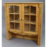 A pine wall cabinet (the top section of a bookcase) fitted two shelves enclosed by a pair of