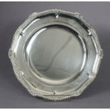 A George III style silver dinner plate with gadrooned rim to the raised shaped border, 10¼”;