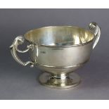 An Edwardian silver trophy bowl with moulded rims & scroll handles, on short round pedestal foot,
