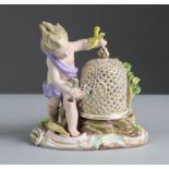 A Meissen porcelain figure of a putto, with birdcage & two birds, representing the element of Air,