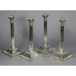 A SET OF FOUR GEORGE III SILVER CANDLESTICKS with round tapered stop-fluted columns & composite