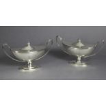 A PAIR OF GEORGE III SILVER OVAL TWO-HANDLED SAUCE TUREENS & COVERS with urn finials, reeded rims,
